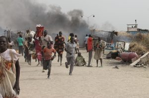TOPSHOT - South Sudanese civilians flee fighting in an United Nations base in the northeastern town of Malakal on February 18, 2016, where gunmen opened fire on civilians sheltering inside killing at least five people.

Gunfire broke out in the base in Malakal in the northeast Upper Nile region on February 17, 2016 night, with clashes continuing on Thursday morning that left large plumes of smoke rising from burning tents in the camp which houses over 47,000 civilians.
 / AFP / Justin LYNCH        (Photo credit should read JUSTIN LYNCH/AFP via Getty Images)